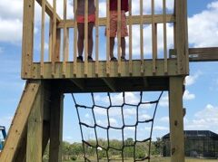 Kids waving on play gym