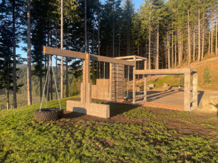 Outside gym made out of wood with ropes to climb on.