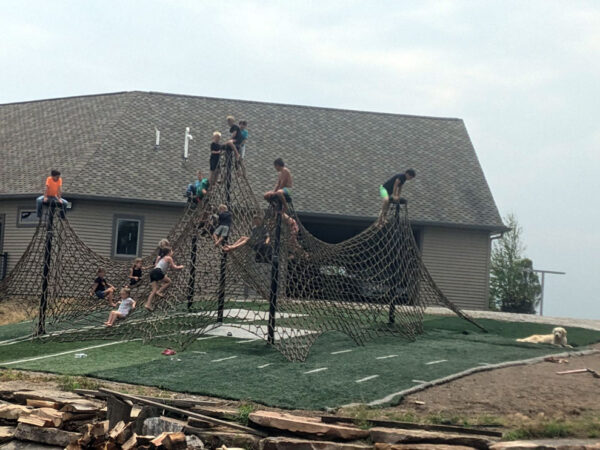 Young boys and girls playing on huge net.