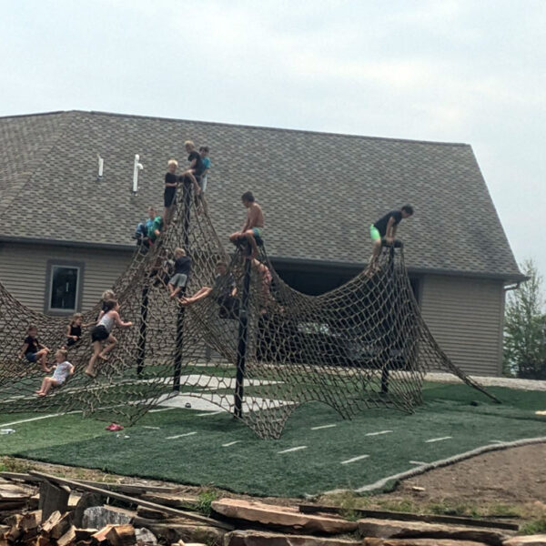 Young boys and girls playing on huge net.